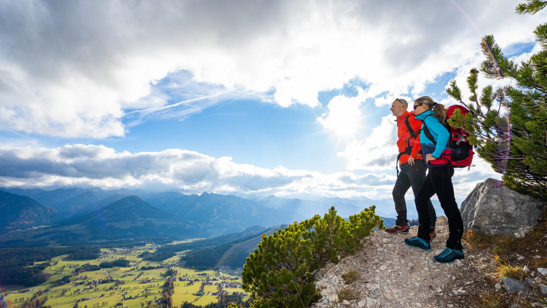 Paar steht an einem Hang und schaut ins Tal: Mancher Freizeitsport ist besonders gefährlich.