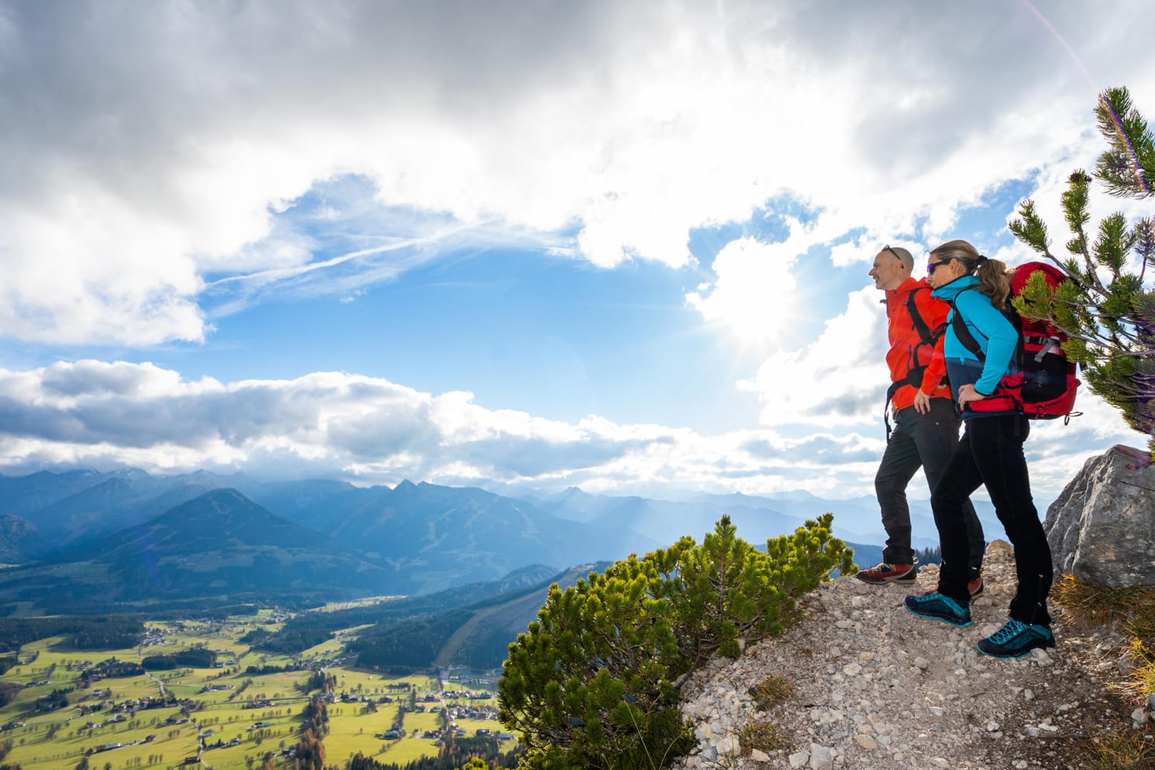 Paar steht an einem Hang und schaut ins Tal: Mancher Freizeitsport ist besonders gefährlich.