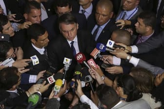 Brasiliens Präsident Jair Bolsonaro (M) spricht mit Journalisten, nachdem er das Dekret zum gelockerten Waffenrecht unterzeichnet hat.