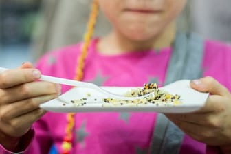 Ein Kind probiert auf einem Stand bei der internationalen Ernährungsmesse "Anuga" Quinoa.