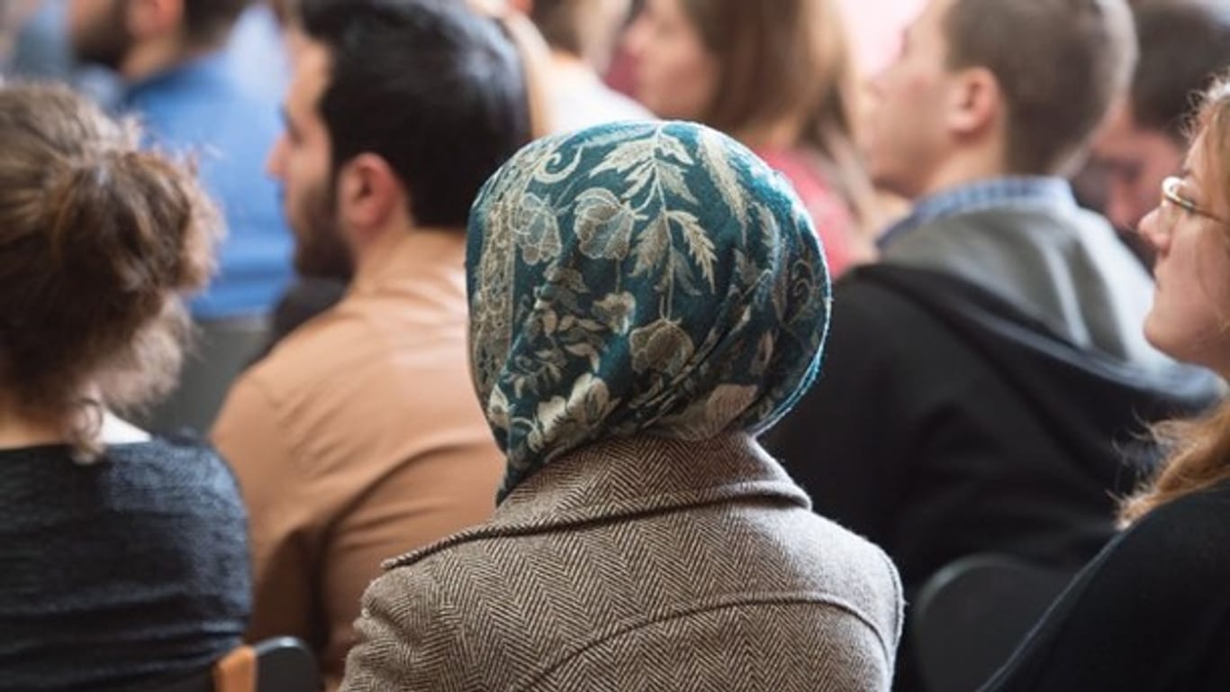Eine Frau mit Kopftuch sitzt während einer Veranstaltung im Publikum (Archivbild): An der Frankfurter Universität hat eine Tagung über das islamische Kopftuch begonnen.