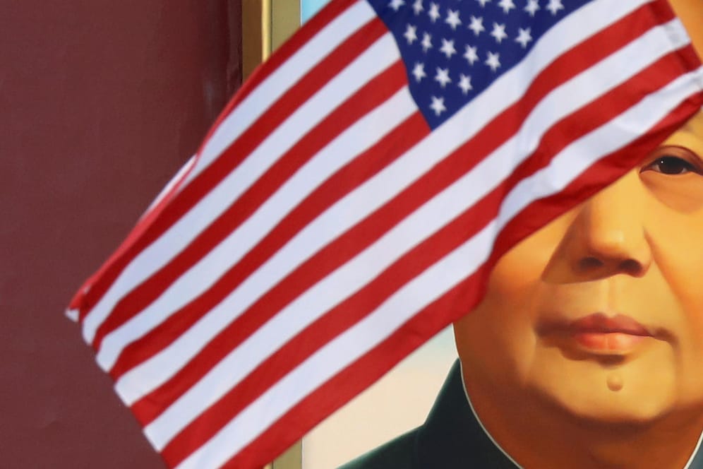 Die US-Flagge vor einem Portrait von Chinas Revolutionsführer Mao Tse Tung: Die beiden Nationen liefern sich zähe Verhandlungen um ein Handelsabkommen.