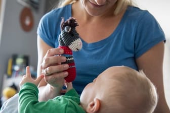 Mutter spielt mit Kind: Bleiben arbeitende Mütter nach der Geburt des Kindes einige Zeit zu Hause, müssen sie deutliche Lohneinbußen hinnehmen.