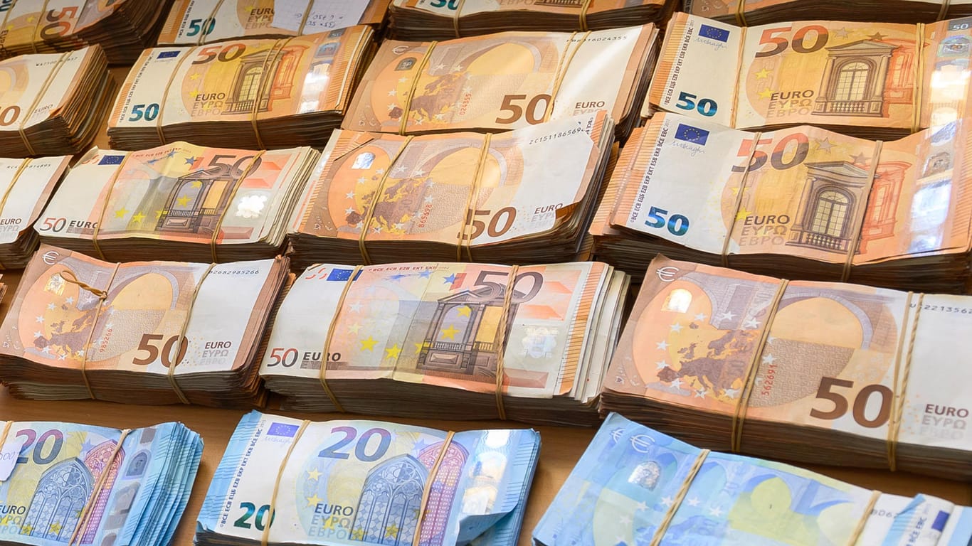 Geldbündel liegen auf einem Tisch: Unter den Vorzeichen einer schwächeren Konjunktur stellt Bundesfinanzminister Olaf Scholz die Ergebnisse der neuen Steuerschätzung vor.
