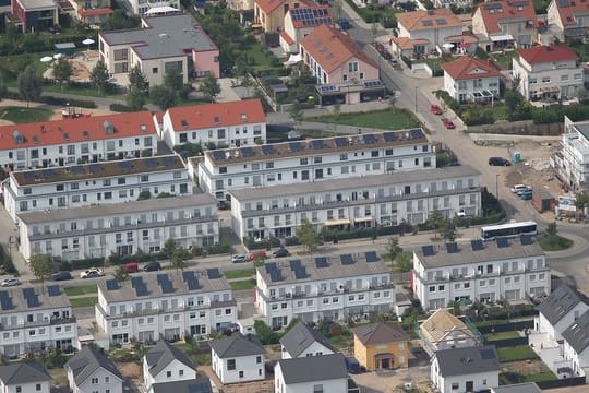 Eine Luftaufnahme zeigt Mehrfamilienhäuser und Reihenhäuser in Köln.