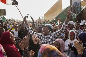 Sudanesische Demonstranten feiern die Verhaftung des langjährigen Präsidenten Omar al-Bashir durch die Streitkräfte außerhalb des Verteidigungsministeriums.