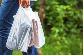 Ein Mann trägt Plastiktüten: Die EU will Einwegprodukte aus Plastik verbieten.