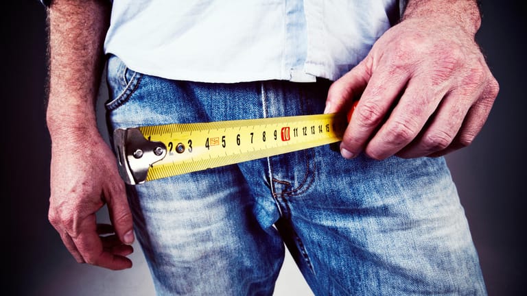 Mann hält Zentimeterband an seine Hose: Ein Eingriff am Penis kann schwere Folgen haben.