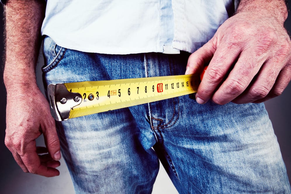 Mann hält Zentimeterband an seine Hose: Ein Eingriff am Penis kann schwere Folgen haben.