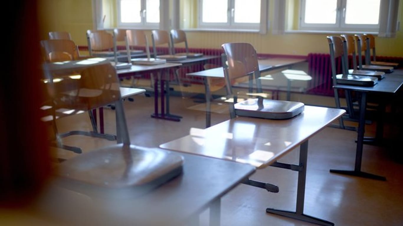Hochgestellte Stühle stehen in einem Klassenraum.