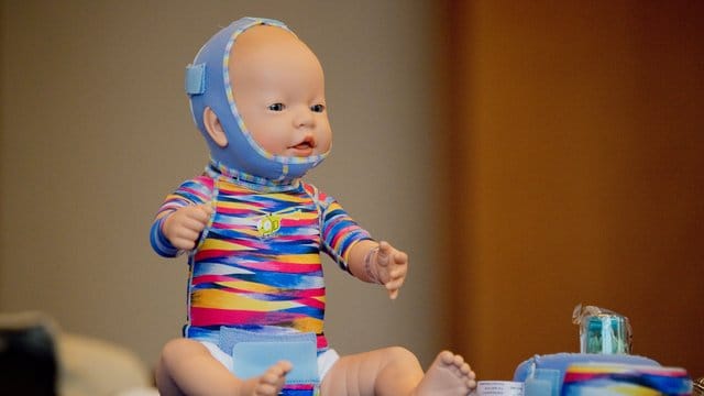 Eine Babypuppe mit Narbenkompressionskleidung: Kleinkinder sind besonders gefährdet, schwere Brandverletzungen zu erleiden. Eine Babypuppe mit Narbenkompressionskleidung: Kleinkinder sind besonders gefährdet, schwere Brandverletzungen zu erleiden.