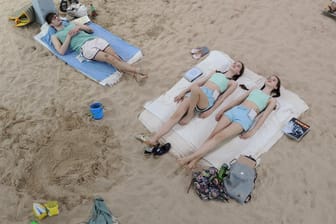 Blick auf die Performance "Sun & Sea (Marina)" der litauischen Künstlerinnen Rugile Barzdziukaite, Vaiva Grainyte und Lina Lapelyte: Auf einem in einem alten Gebäude der Marine aufgeschütteten Strand liegen Sänger, die unter anderem über den Klimawandel singen.