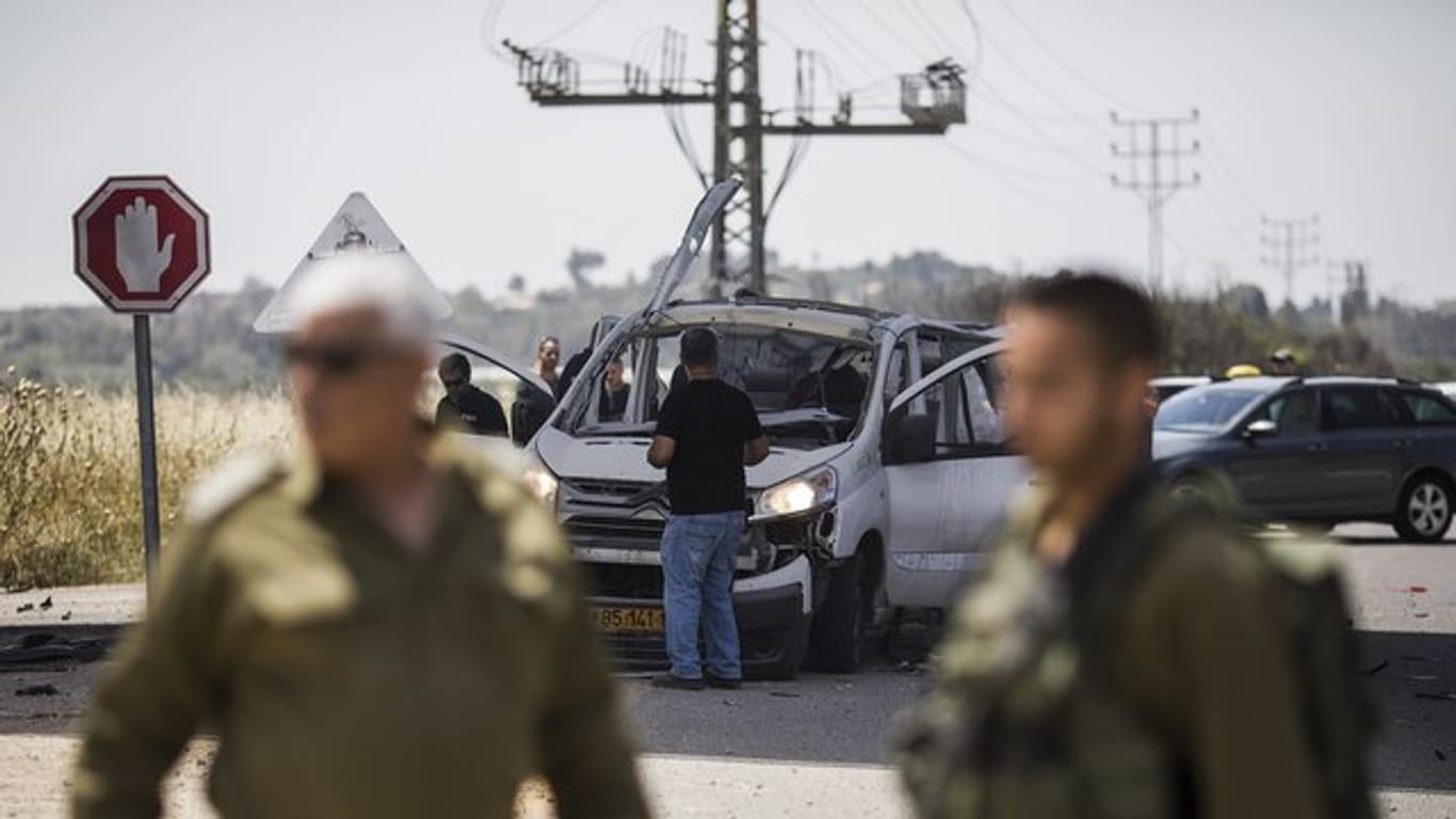 Israelische Soldaten vor einem zerstörten Auto am Grenzübergang Erez.