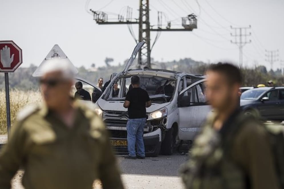Israelische Soldaten vor einem zerstörten Auto am Grenzübergang Erez.