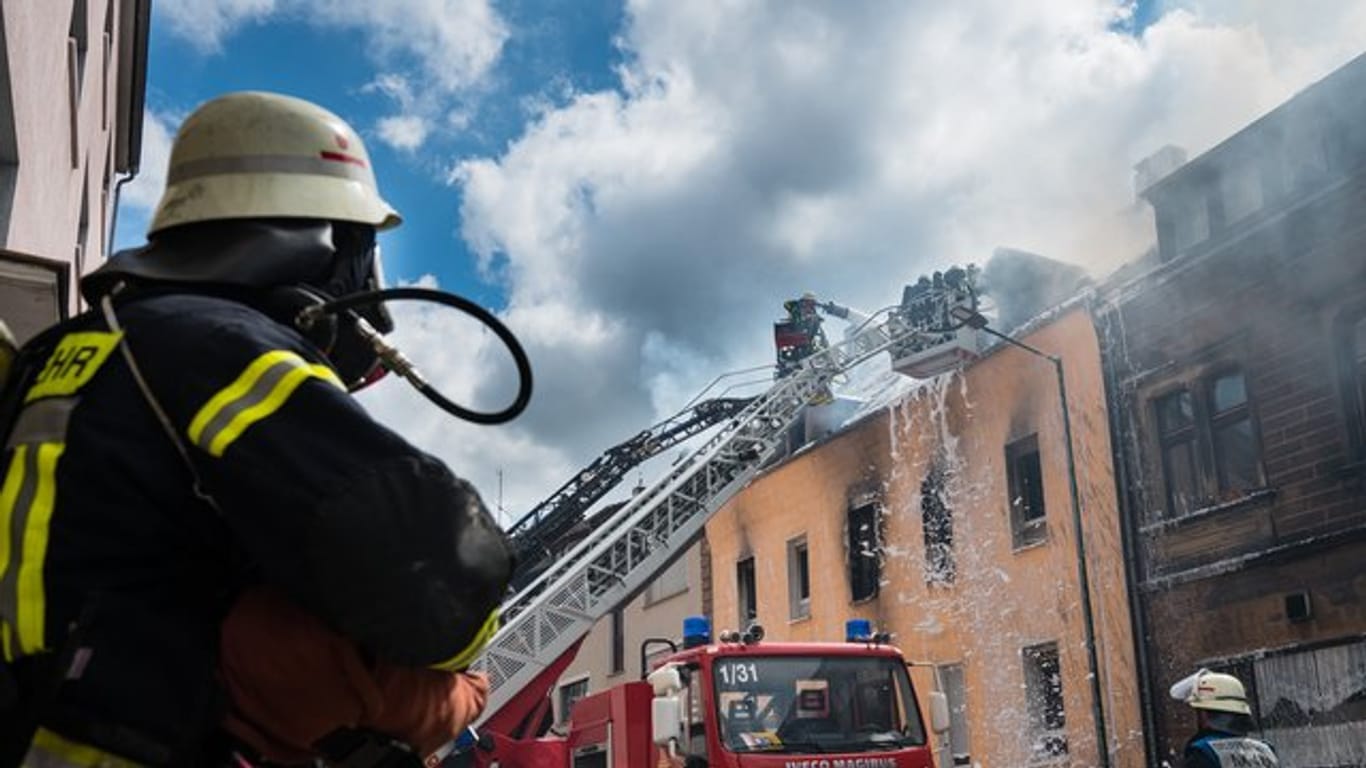 Einsatzkräfte der Feuerwehr löschen den Brand in dem Mehrfamilienhaus in Neunkirchen.