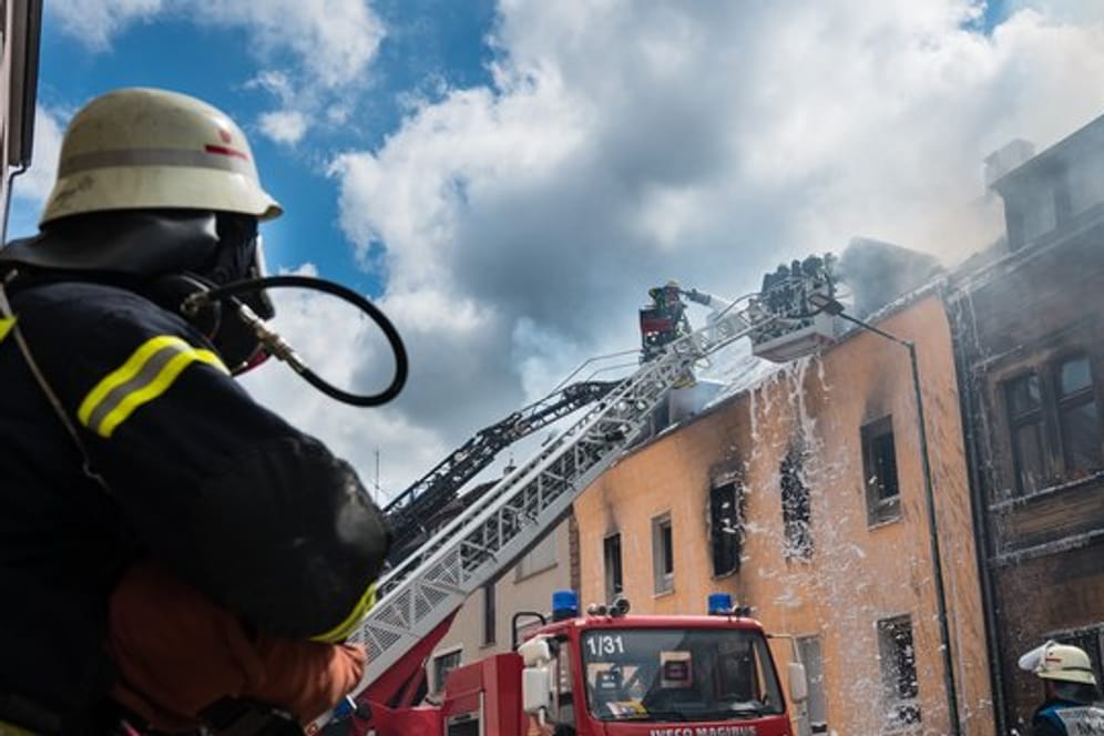 Einsatzkräfte der Feuerwehr löschen den Brand in dem Mehrfamilienhaus in Neunkirchen.
