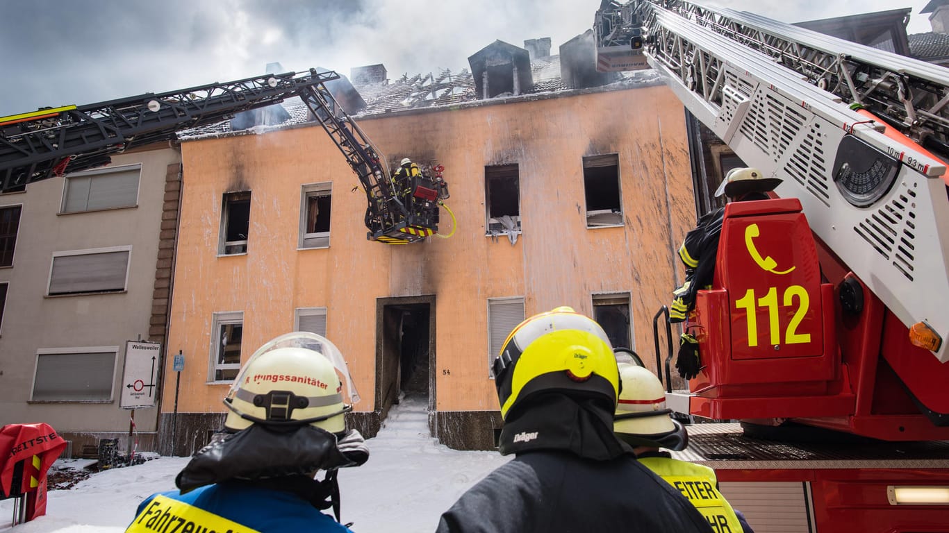 Die Feuerwehr löscht den Brand eines Mehrfamilienhauses: Bei dem Feuer sind mehrere Menschen verletzt worden, drei Bewohner wurden vermisst.
