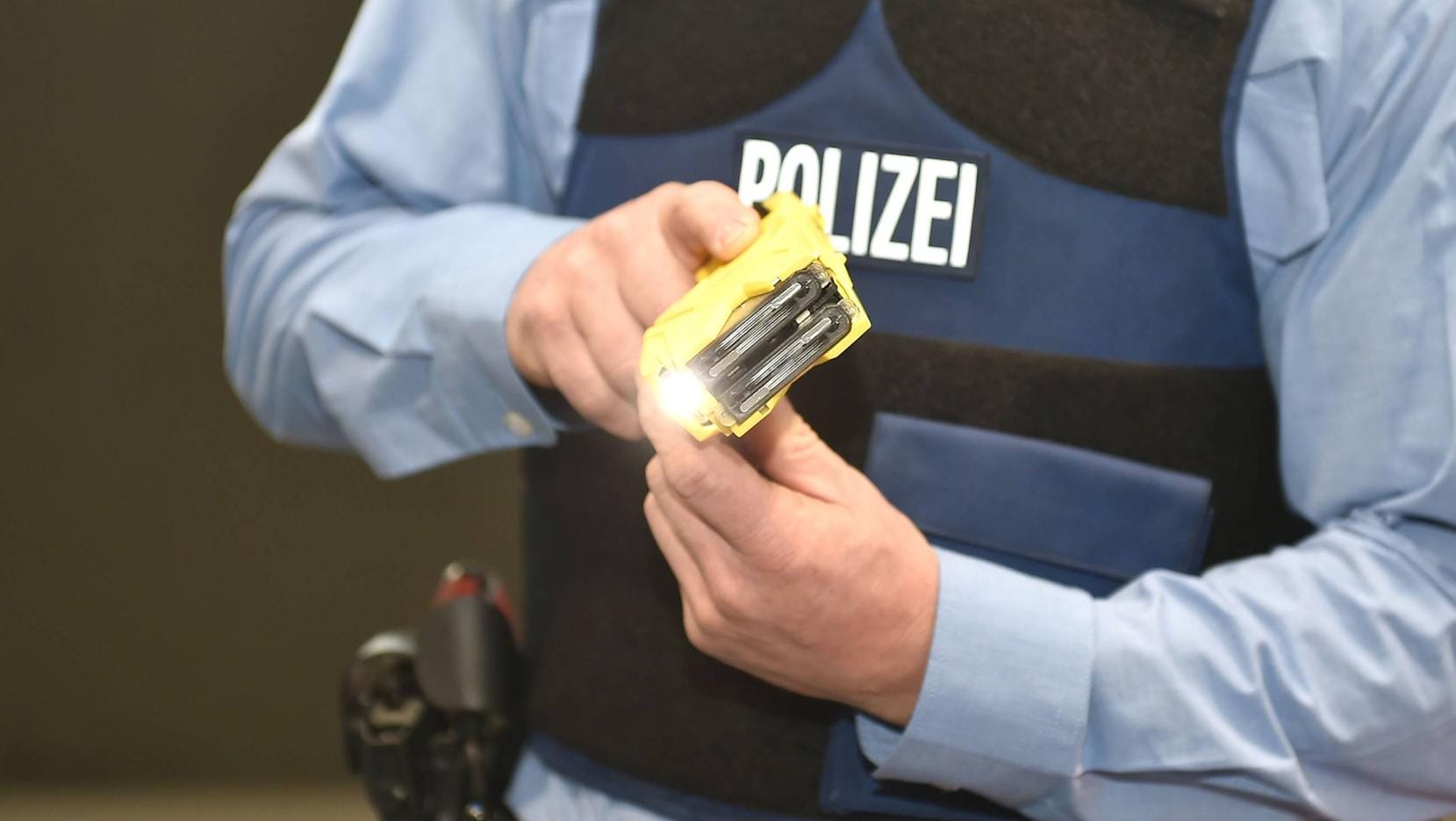 Ein Polizeibeamter mit einem Taser (Symbolfoto): Nach dem Stromstoß sei der Mann kollabiert, habe sich übergeben und sei in die Uniklinik gebracht worden.