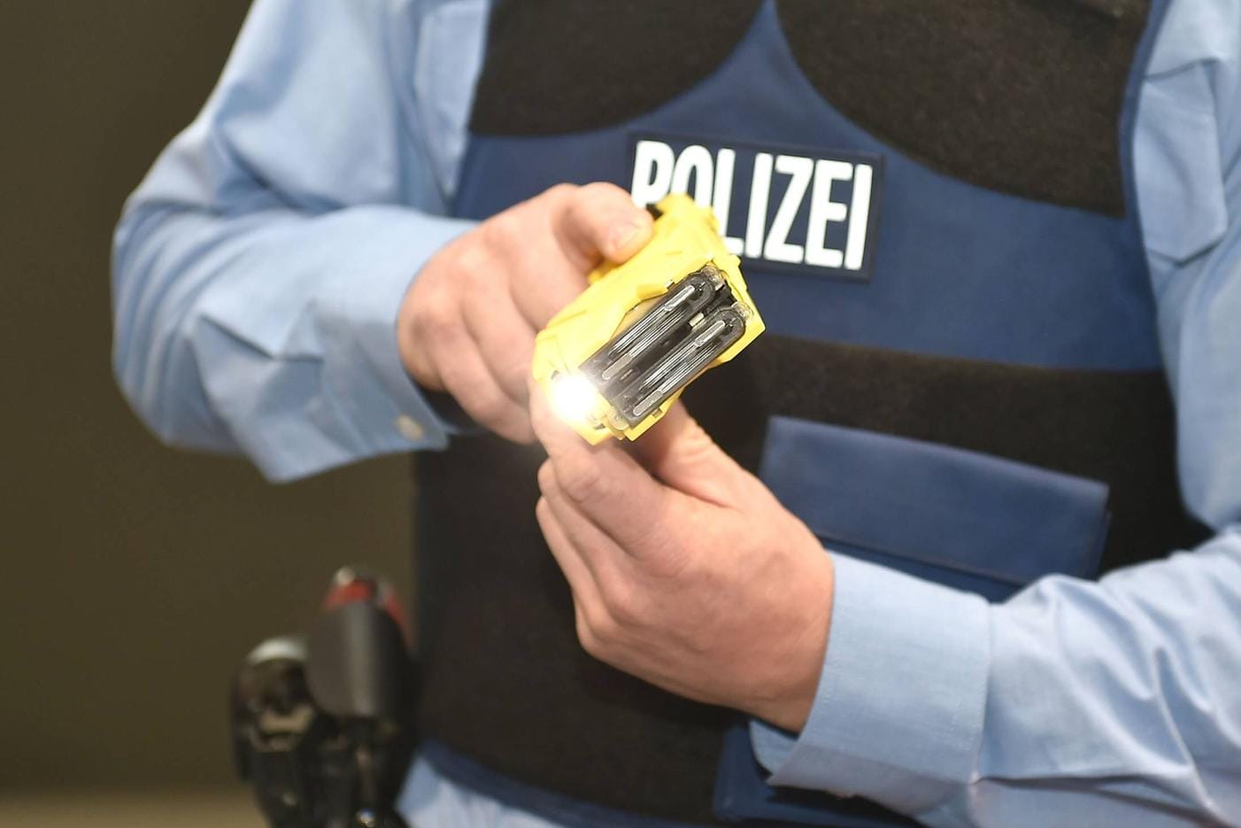 Ein Polizeibeamter mit einem Taser (Symbolfoto): Nach dem Stromstoß sei der Mann kollabiert, habe sich übergeben und sei in die Uniklinik gebracht worden.