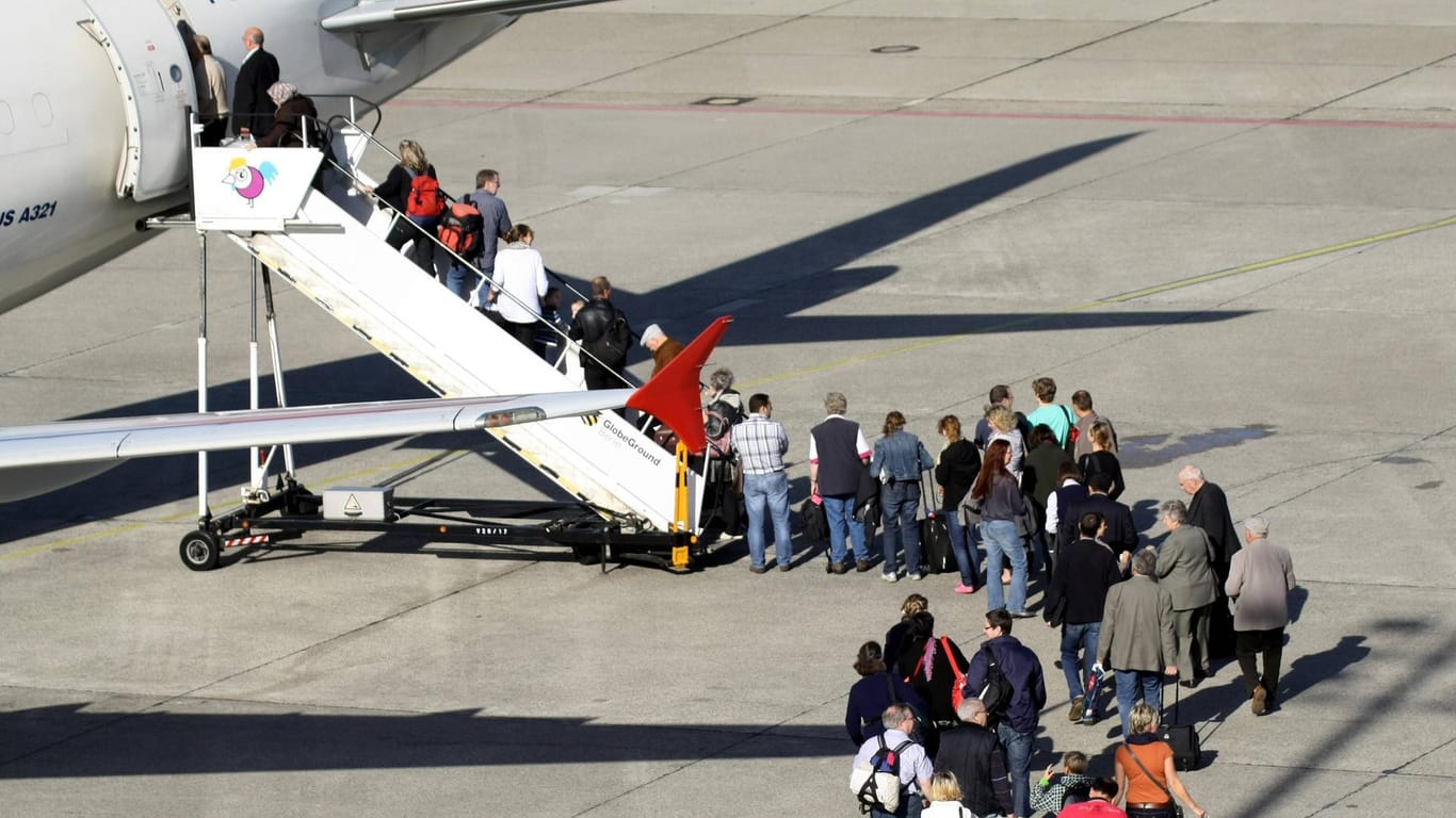 Passagierschlange steigt ins Flugzeug ein: Ein Großteil der Deutschen würde für das Klima Flugreisen reduzieren.