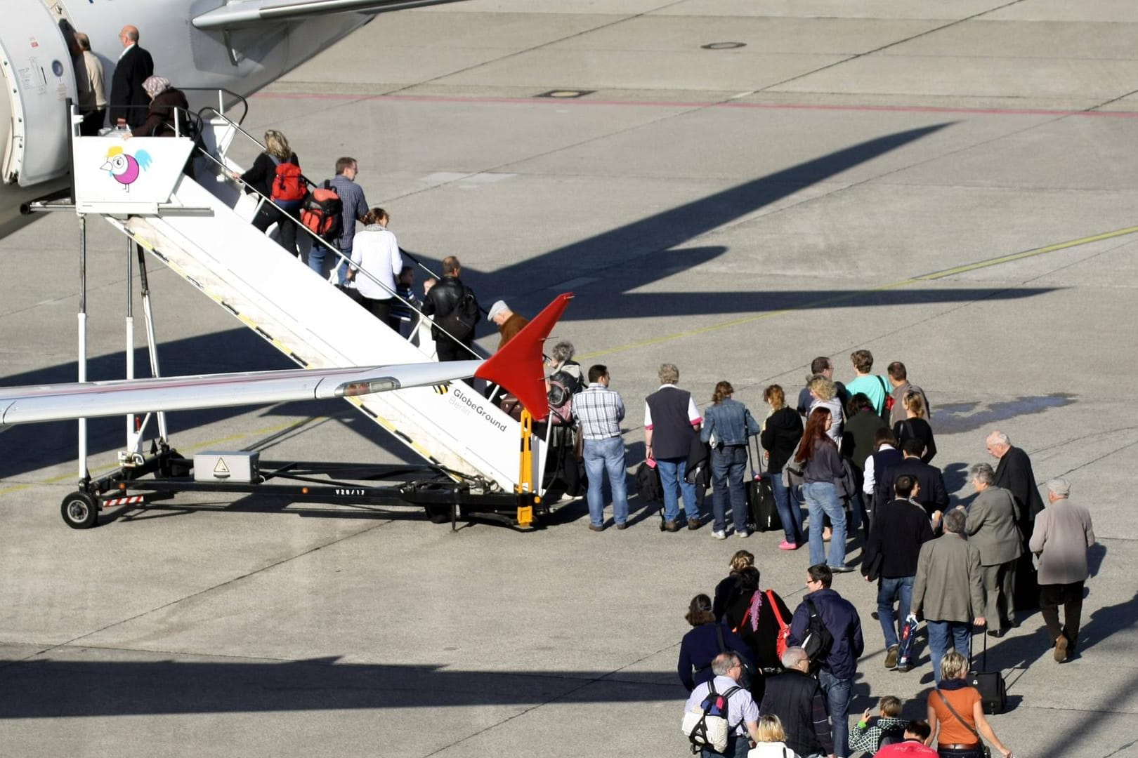 Passagierschlange steigt ins Flugzeug ein: Ein Großteil der Deutschen würde für das Klima Flugreisen reduzieren.