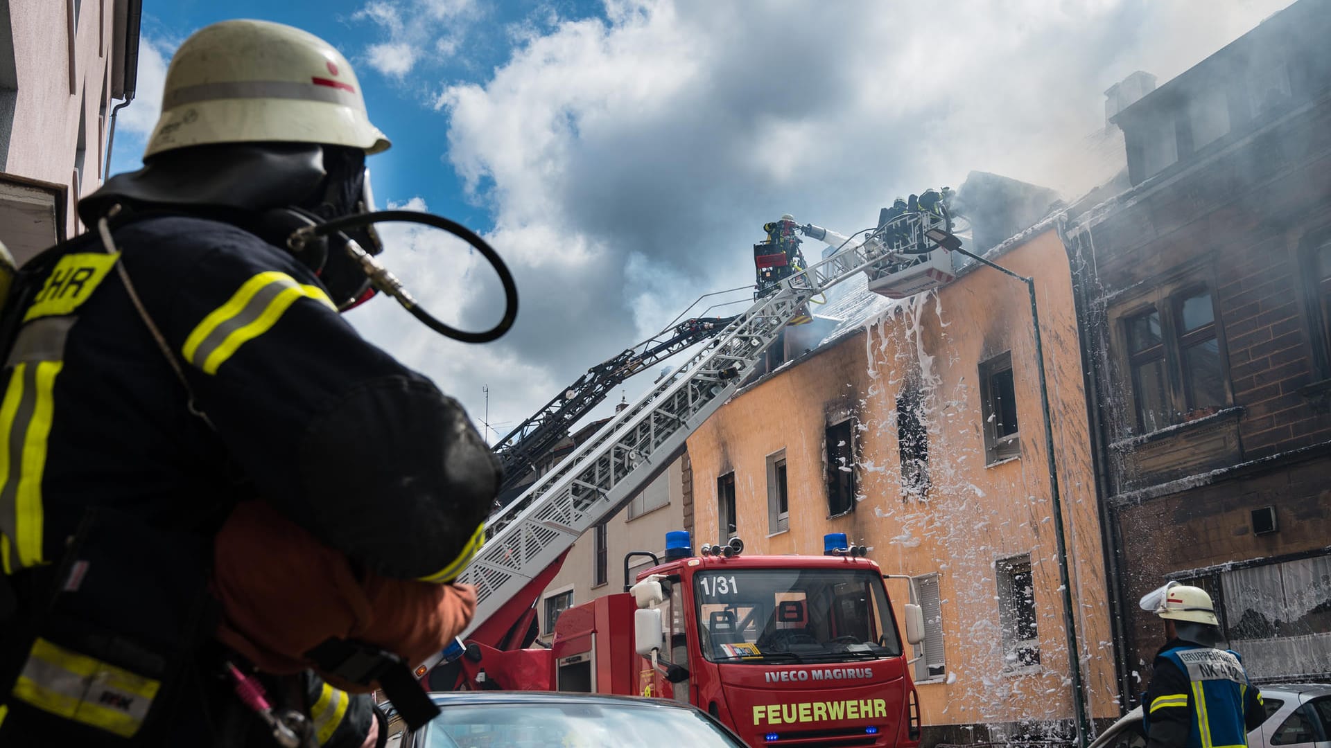 Saarland, Neunkirchen: Einsatzkräfte der Feuerwehr löschen den Brand eines Mehrfamilienhauses.