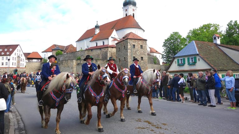 Festlich gekleidete Männer reiten durch Bad Kötzting: An der eucharistischen Prozession zu Pferde beteiligen sich alljährlich über 900 Reiter in den überlieferten Trachten.
