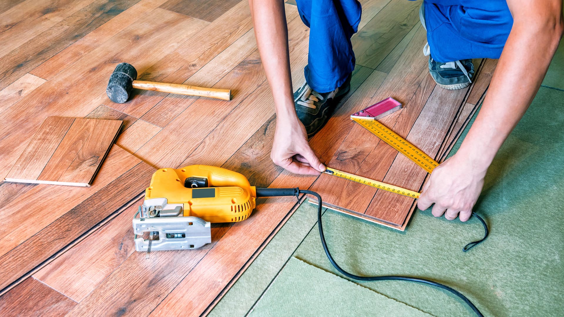 Handwerker verlegt Laminat: Die Wartezeit bei Handwerksbetrieben wird immer länger.