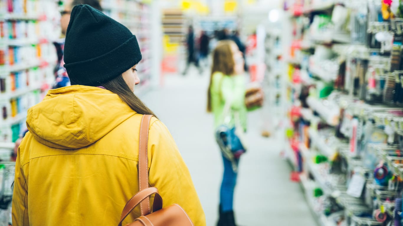 Frau mit Rucksack im Supermarkt: Darf das Personal eines Supermarktes die Taschen von Kunden durchsuchen?