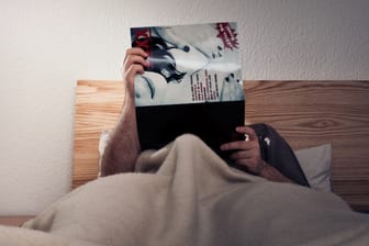 Mann im Bett: Selbstbefriedigung kann sich positiv auf die Gesundheit auswirken.