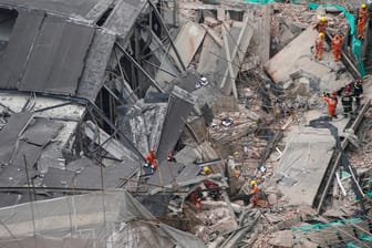 Rettungskräfte suchen im eingestürzten Gebäude nach Verschütteten: Ein Mercedes-Autohaus ist in Shanghai zum Teil kollabiert.