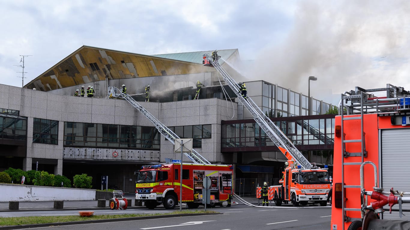 Feuerwehrleute löschen von Drehleitern aus ein Feuer, das in der Rheingoldhalle ausgebrochen war: Das Feuer konnte nach einem mehrstündigen Einsatz unter Kontrolle gebracht werden.