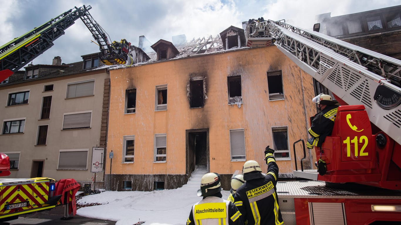 Einsatzkräfte der Feuerwehr löschen den Brand des Mehrfamilienhauses: Bei dem Feuer sind mehrere Menschen verletzt worden.