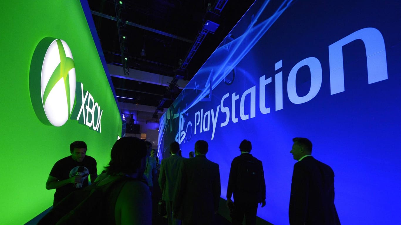 Besucher einer Spielemesse laufen an den Ständen von Xbox und Playstation vorbei: Die Konsolen-Konkurrenten Microsoft und Sony wollen ihre Kräfte bündeln.