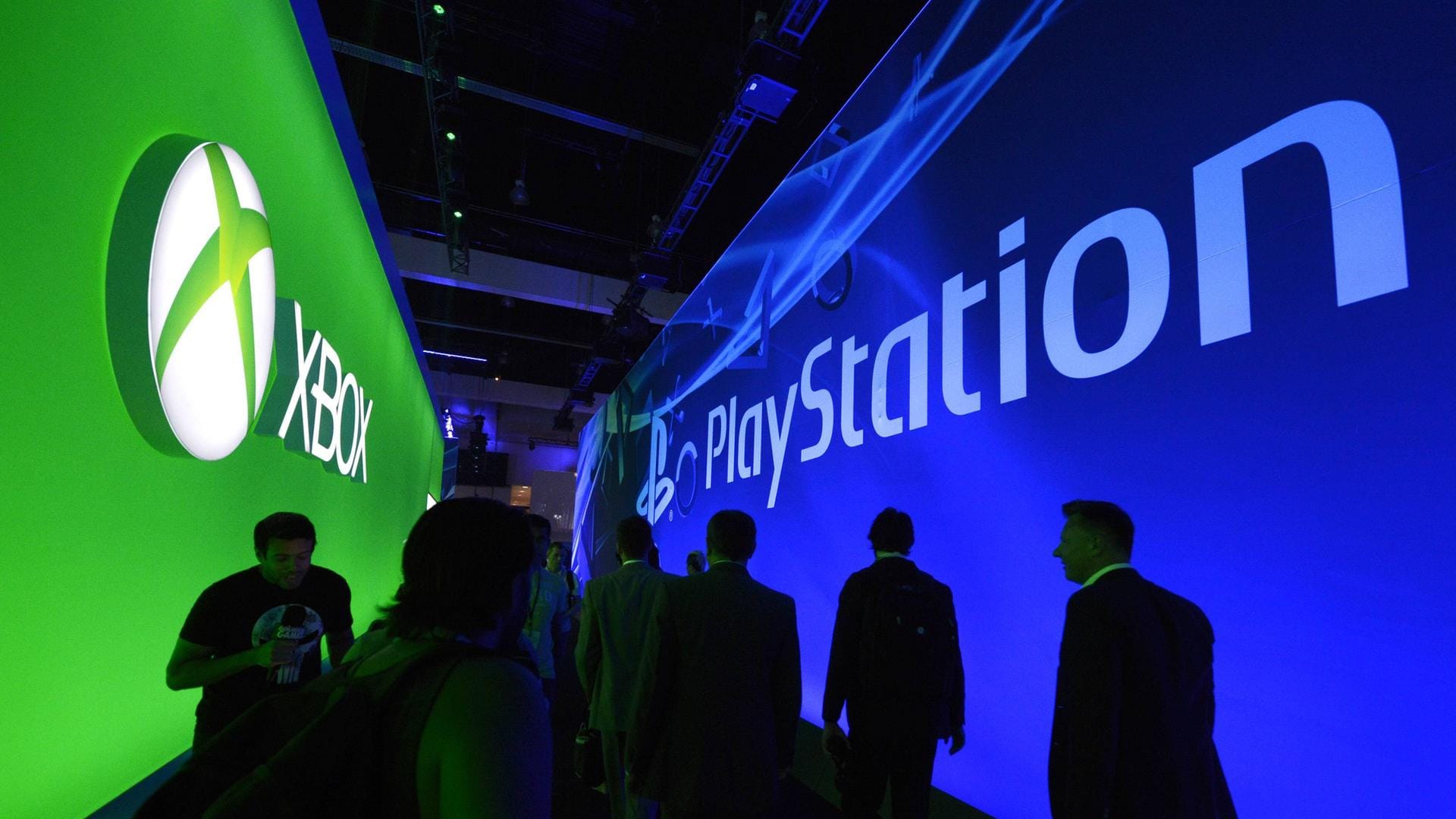 Besucher einer Spielemesse laufen an den Ständen von Xbox und Playstation vorbei: Die Konsolen-Konkurrenten Microsoft und Sony wollen ihre Kräfte bündeln.