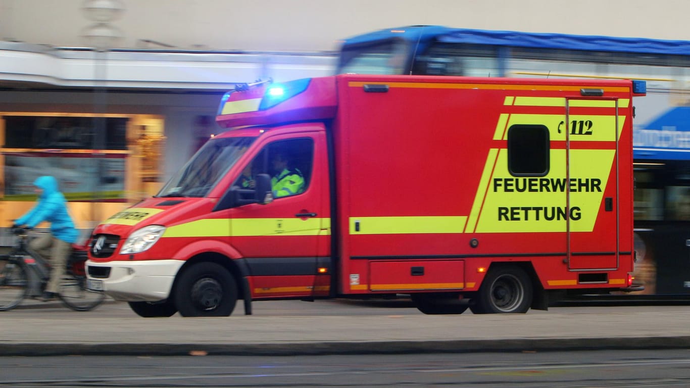 Feuerwehr-Rettungswagen mit Blaulicht (Symbolbild): Ein Baukran ist in Schleswig-Holstein auf ein Gebäude gestürzt und hat großen Schaden verursacht.