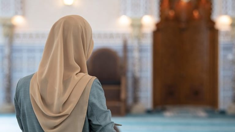 Eine Muslima mit einem Kopftuch im Gebetsraum einer Moschee.