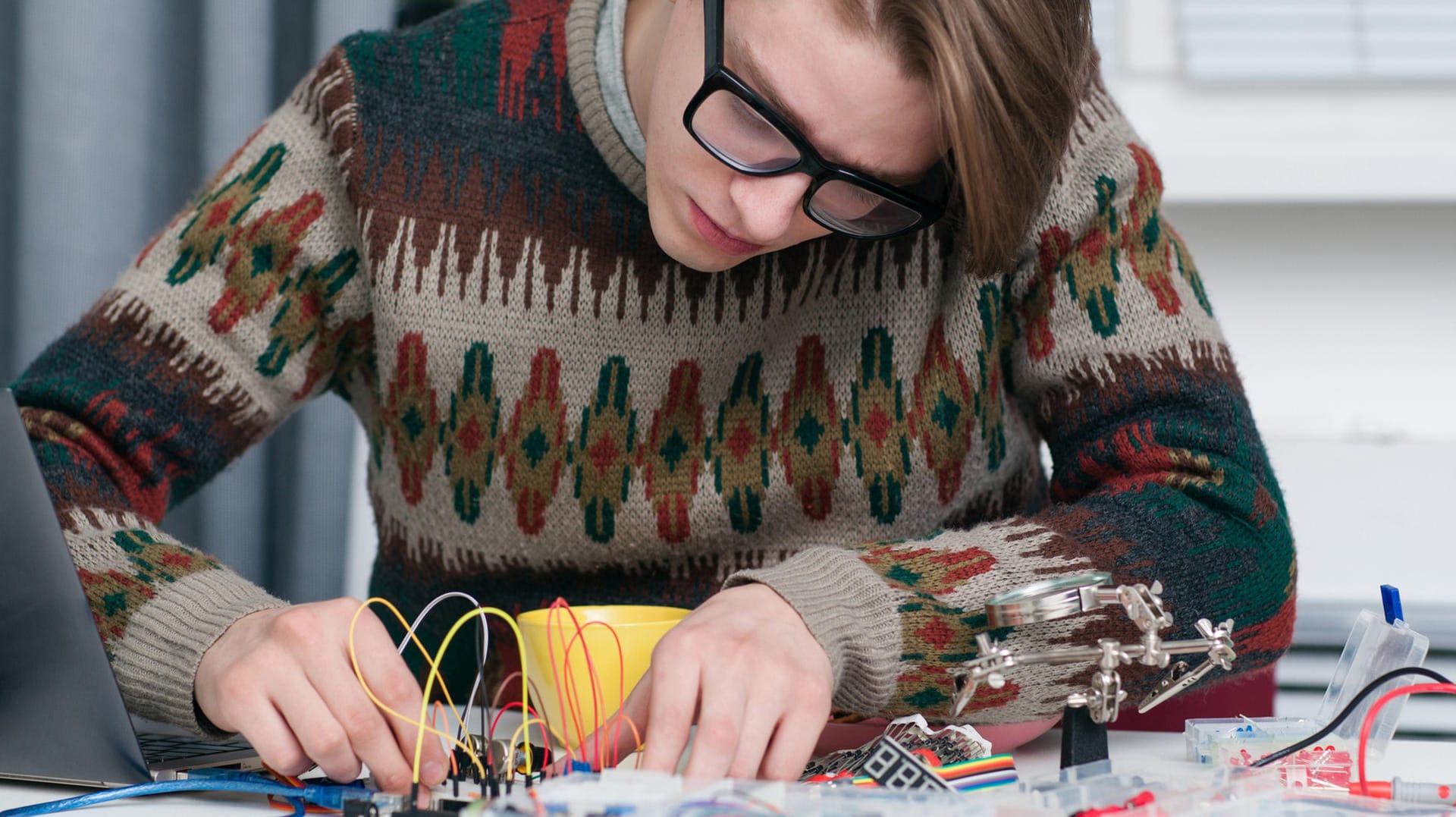 Ein junger Mann arbeitet mit Elektronikteilen: Kennen Sie die großen Erfinder?