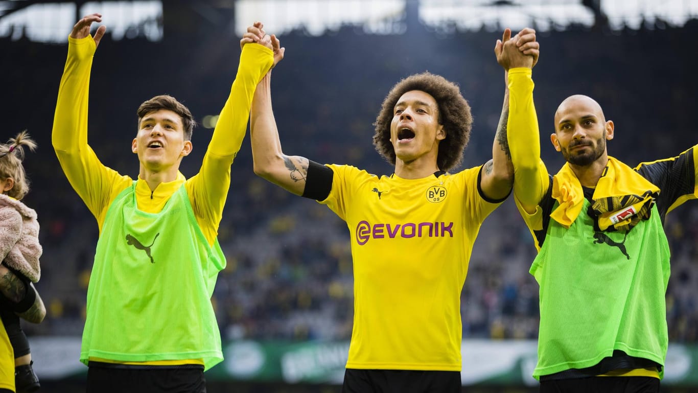 Die Dortmunder Balerdi (v. l.), Witsel und Toprak jubeln vor der Fankurve: Die Unterstützung der deutschen Sport-Fans ist dem BVB gewiss.