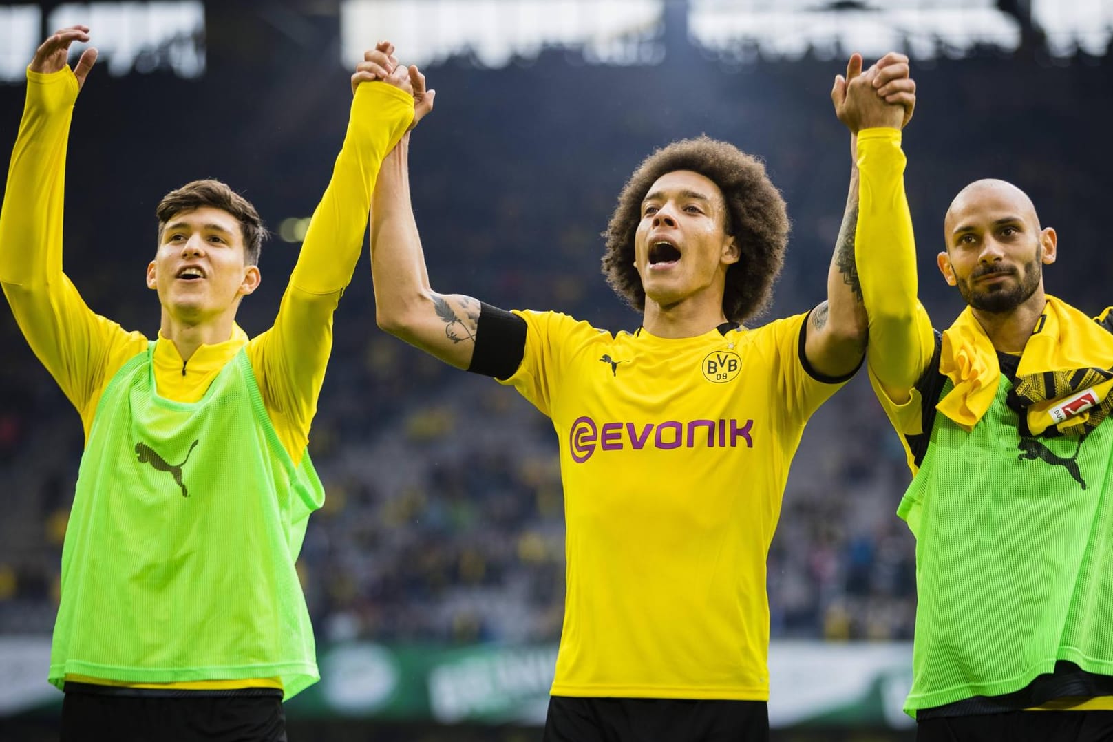Die Dortmunder Balerdi (v. l.), Witsel und Toprak jubeln vor der Fankurve: Die Unterstützung der deutschen Sport-Fans ist dem BVB gewiss.