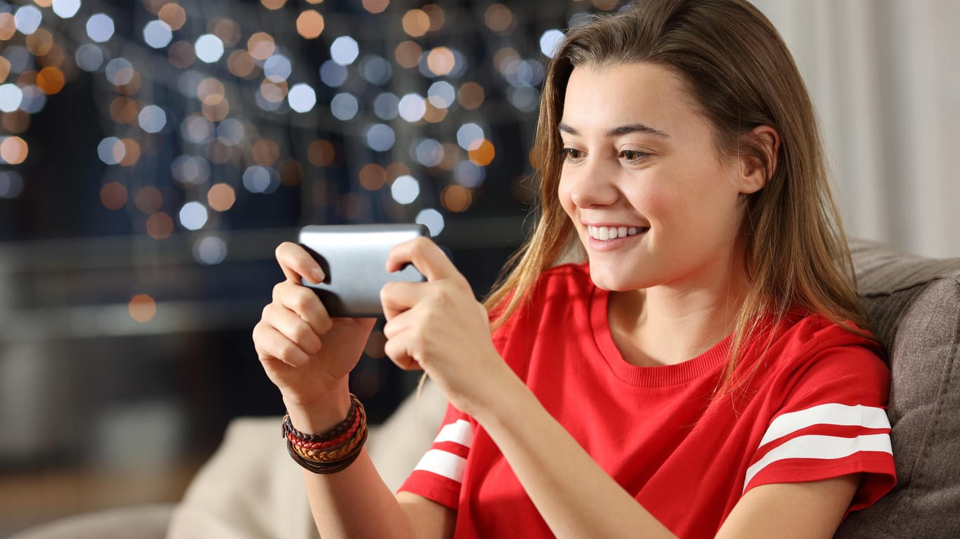 Eine Frau spielt am Smartphone (Symbolbild): Steam-Nutzer können ihre Spiele auf Android- oder iOS-Geräte streamen.