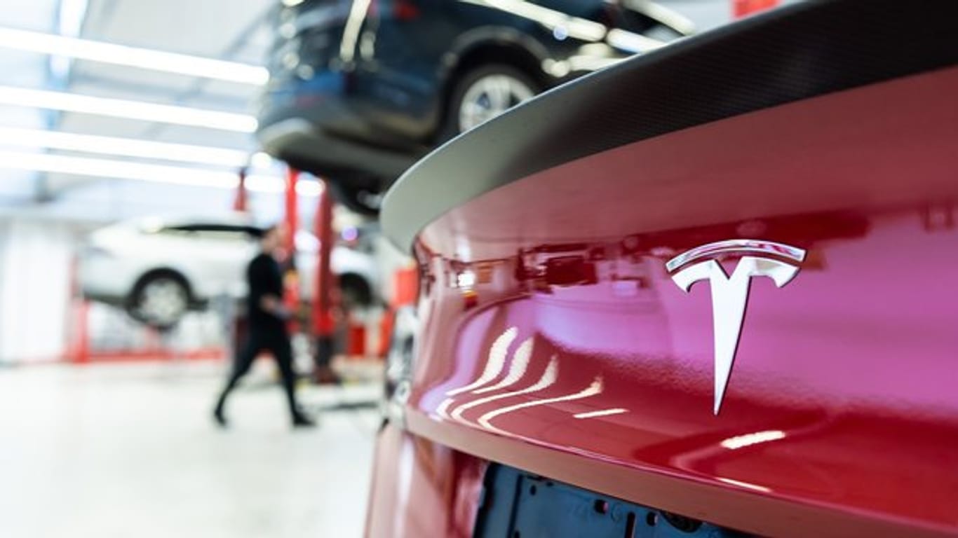 Das Logo des Fahrzeugherstellers Tesla auf einem Fahrzeug in einem Tesla Service Center.