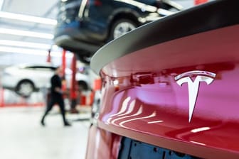 Das Logo des Fahrzeugherstellers Tesla auf einem Fahrzeug in einem Tesla Service Center.