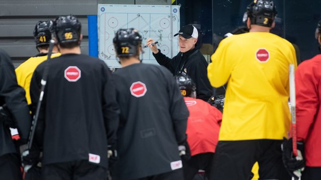 Trainer Toni Söderholm (hinten) bereitet das DEB-Team auf das Spiel gegen Kanada vor.