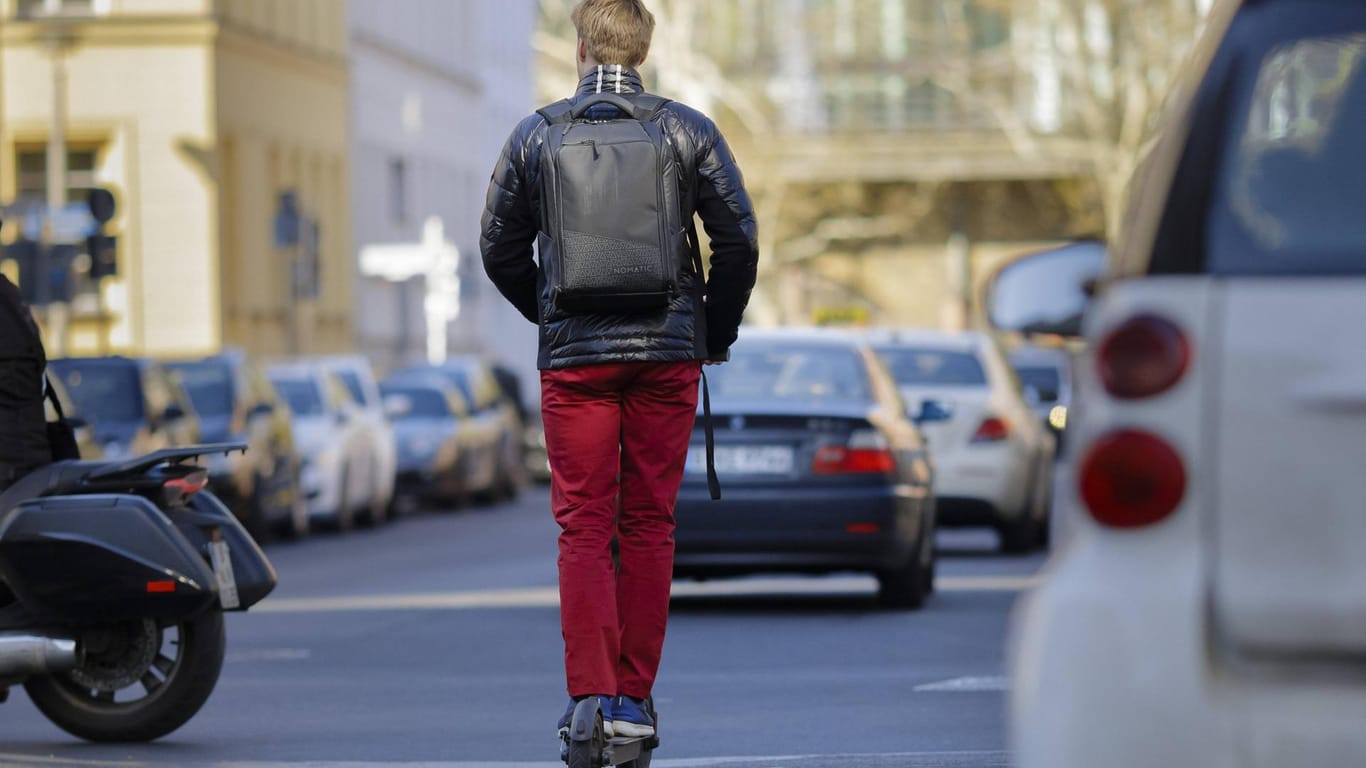 Ein Mann fährt mit einem E-Scooter auf einer Straße: Grundsätzlich sei es aus verkehrsplanerischer Sicht wünschenswert, alle verfügbaren Systeme optimal auszulasten, so ein Experte.
