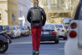Ein Mann fährt mit einem E-Scooter auf einer Straße: Grundsätzlich sei es aus verkehrsplanerischer Sicht wünschenswert, alle verfügbaren Systeme optimal auszulasten, so ein Experte.