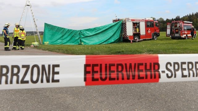 Feuerwehrleute haben auf dem Flugplatz einen Sichtschutz errichtet.