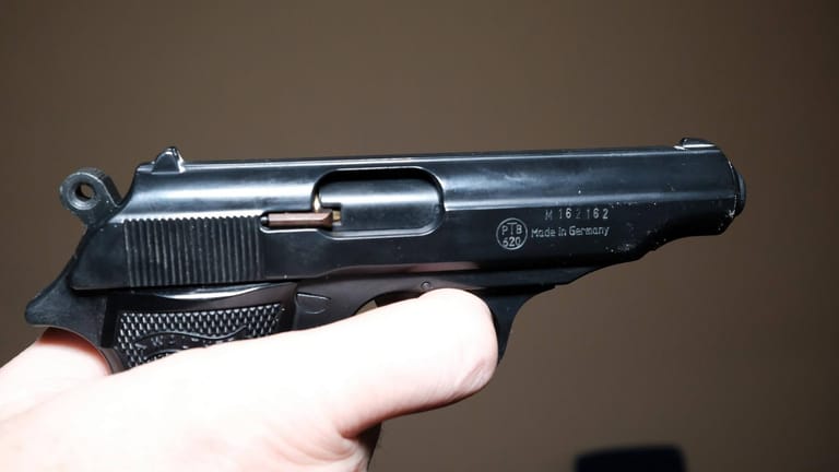 Eine Hand hält eine Schusswaffe: Die Polizei sicherte mehrere Gegenstände in der Wohnung des Mannes, die Schusswaffe fand sie nicht. (Symbolbild)