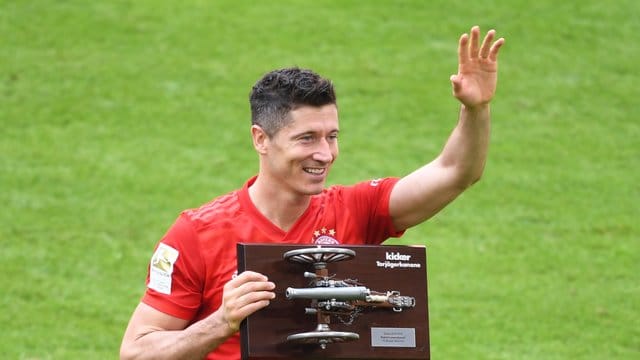 Bayerns Tobert Lewandowski hält die Torjägerkanone in den Händen.