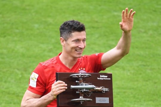 Bayerns Tobert Lewandowski hält die Torjägerkanone in den Händen.